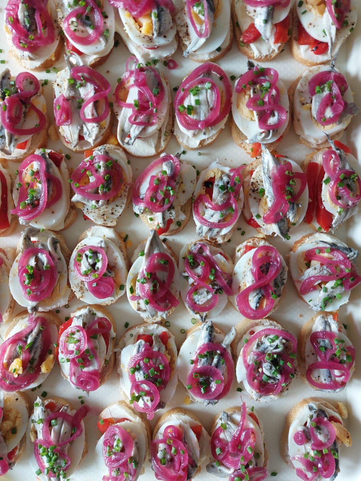 Crostini canapés with pickled red onion and herbs, served by Jack Robinson Catering